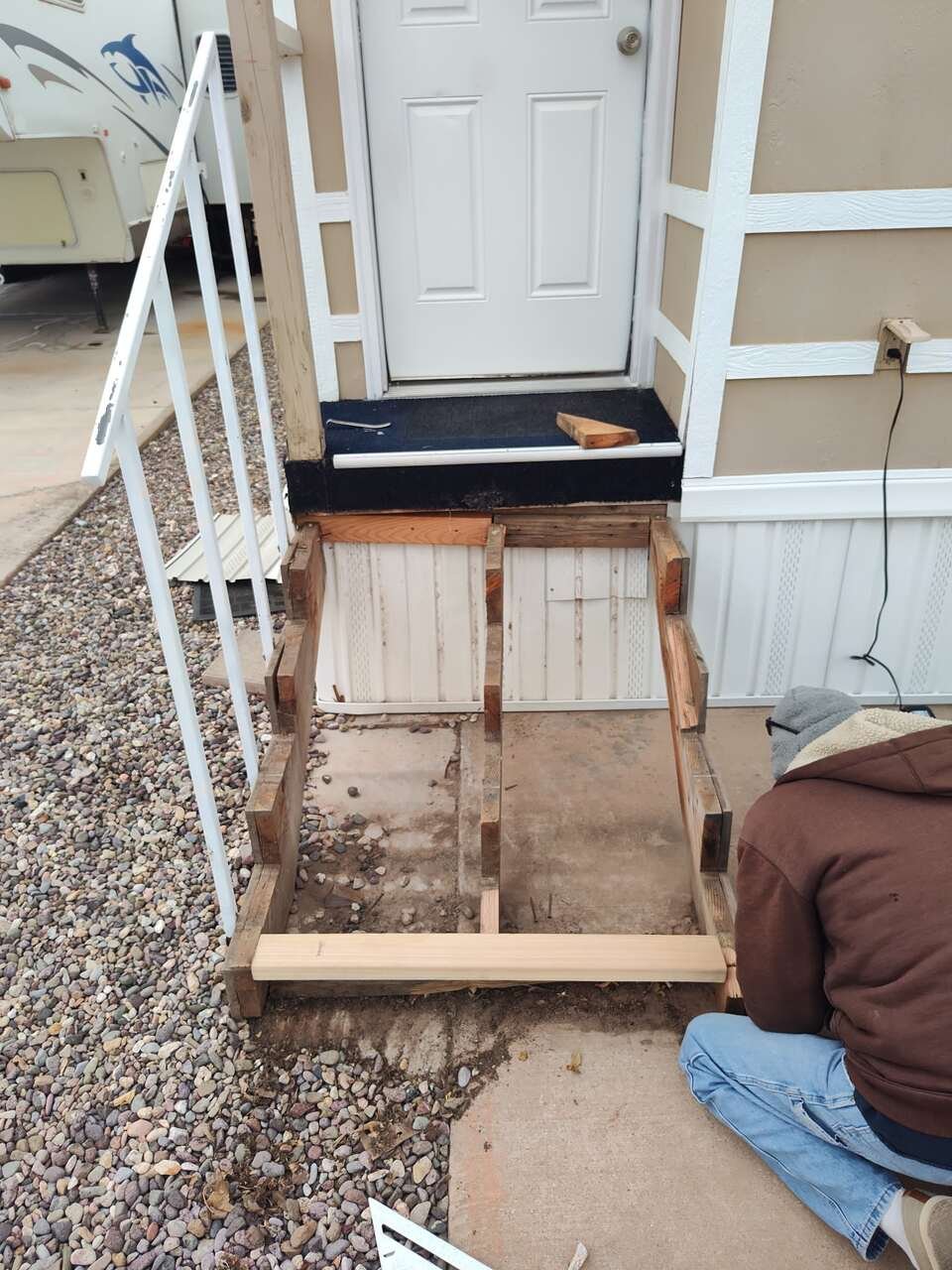 Old wooden entry step frame being removed before new steps are built
