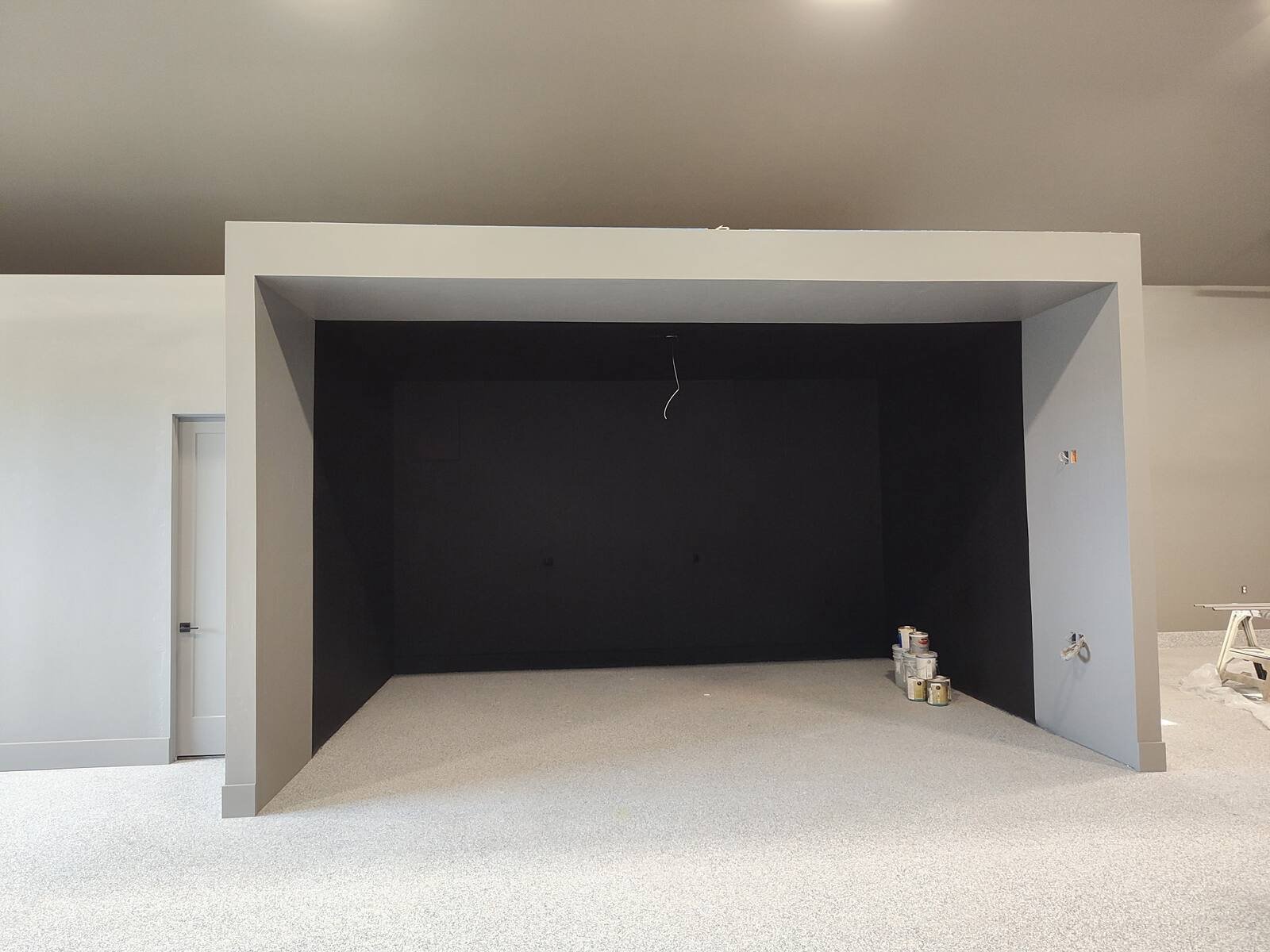 Simulator bay enclosure with freshly painted gray walls and a dark interior